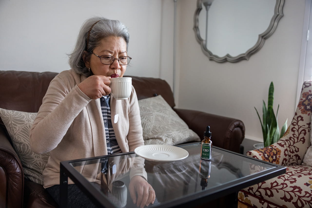 Person drinking tea with CBD oil