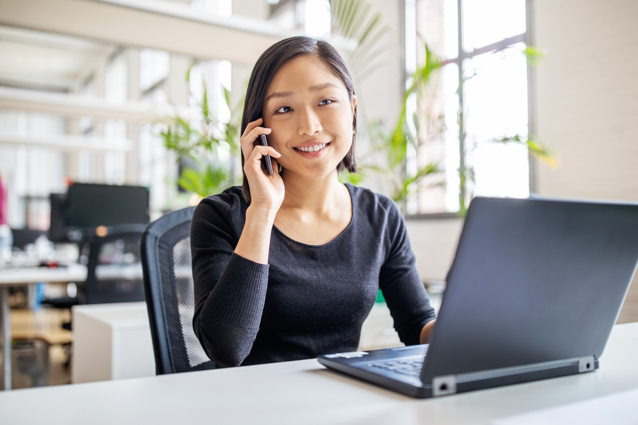 Woman on phone with laptop