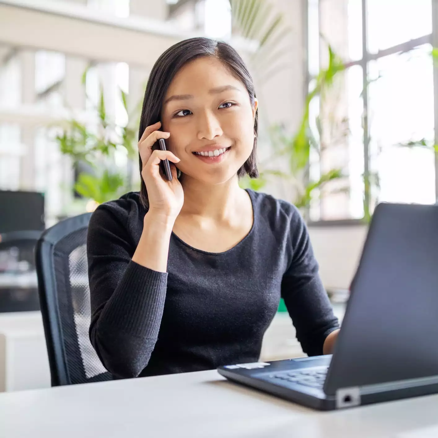 Woman on phone with laptop