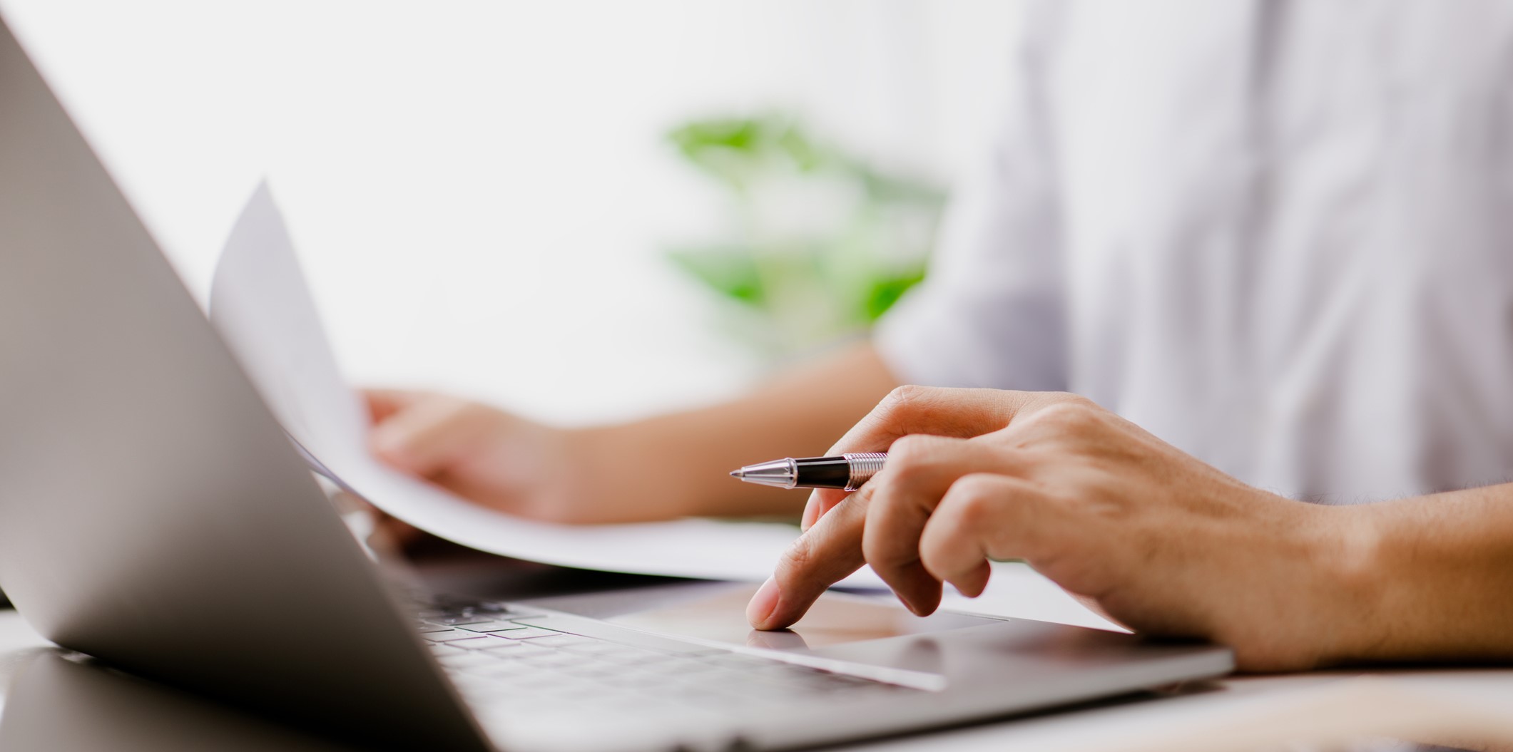 Close up of a pen in hand on laptop