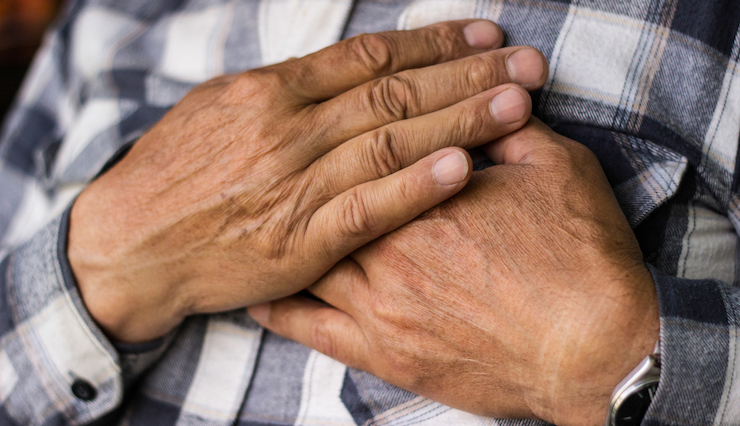 man clutching his hand on his chest and over his heart